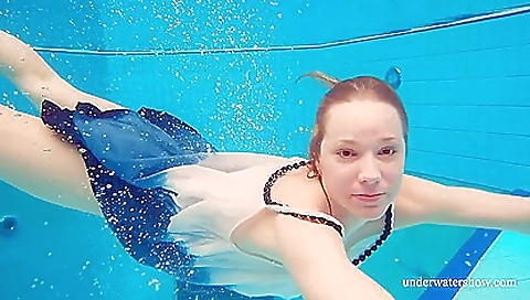 Red-haired teen in a diving suit and bikini in the ocean