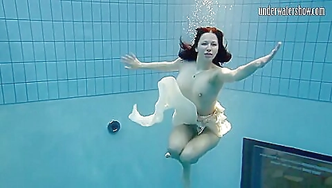 Sexy brunette teen in a pool towel enjoys relaxing in the shower